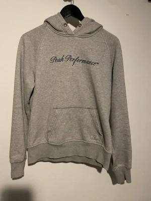 Hoodie - Grå peak performance hoodie i bra skick. Tror det är barn strl L men sitter som vanlig S
