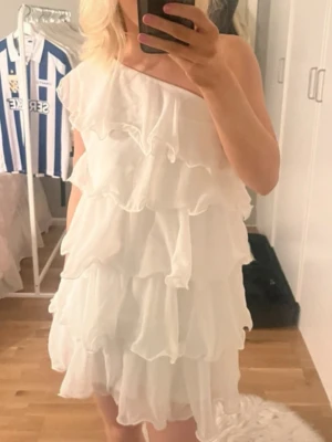 Vit oneshoulderklänning med volanger - Supersöt vit kortklänning perfekt till student eller liknande 🤍. Säljes i storlek 164.