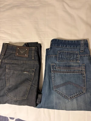 Emporio Armani och Armani Jeans herrjeans - Ett par snygga jeans från Armani. paret är mörkgrått med kontrastsömmar och metallmärke bak, har rak passform och fem fickor. Perfekt för dig som gillar stilrena designer. Storlek W 34 L 32 OBS! Bara det mörkgrå paret är tillgängligt att köpa 