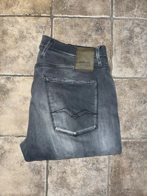Replay Hyperflex jeans  - Säljer ett par Replay Hyperflex Bronny jeans i grå tvätt med snygga slitningar. Slim fit-modell med stretchigt material för skön passform. Midja 41cm, längd 103cm. JAG SKICKAR EJ FLER BILDER NÄR JAG BÄR JEANSEN! för storleksguide hänvisar jag till måtten och för bättre inblick i passformen rekommenderar jag att googla på modellnamnet. kolla måtten noggrant :) !!
