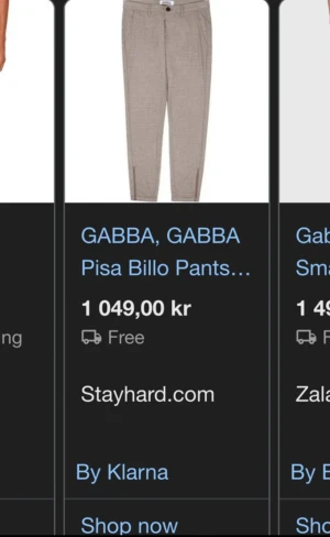 Beige rutiga kostymbyxor från Gabba - Snygga beige kostymbyxor från Gabba med diskret rutigt mönster. Byxorna har klassisk midja, raka ben och knappstängning framtill. Perfekta för en clean och stilren look, passar till skjorta eller t-shirt.