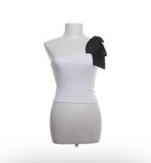Vit oneshoulder topp Zara  - Jättesnygg one shoulder topp med svart rosett från Zara.  Som ny!