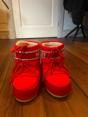 Röda Moon Boot med snörning - Säljer nu mina så gott som nya röda moonboots!! De är använda ca 5 gånger och är därför i väldigt bra skick, storlek 39/41 och passar mig som har storlek 38/39 perfekt. Köpta för 1600kr men säljer de nu för 550kr!😍 Hör av dig vid frågor!