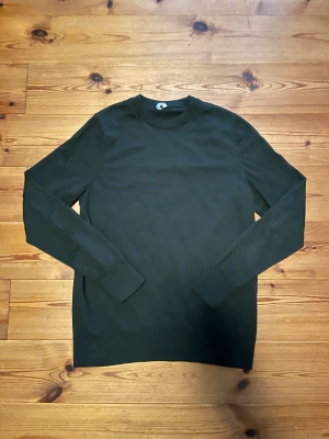 Arket Stickad Merinoull Långarmad Tröja - En riktigt fin stickad långarmad tröja i mörkgrön färg från Arket ✔️ Storlek S ✔️ Den är gjord på merinoull ✔️ Väldigt bra skick ✔️ Inga fläckar eller skador ✔️ Skriv om du undrar något!