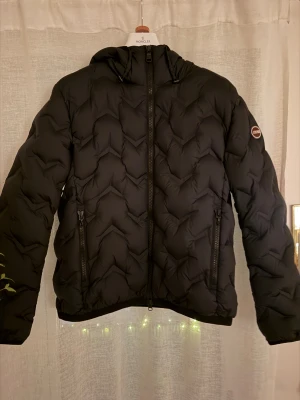Colmar pufferjacka  - Säljer en svart pufferjacka från Colmar med snyggt quiltat mönster och huva. Jackan köptes på Zalando för ungefär 5 000kr ny, den är knappt använd och har inga skador alls, storlek 50 alltså M.
