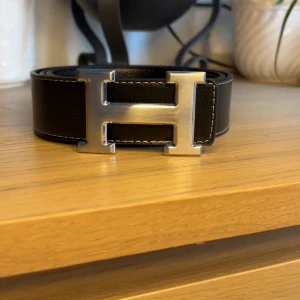 Svart H bälte silver logga - Svart H bälte med silver logga