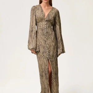 Zebramönstrad långklänning Adoore - Snygg långklänning med zebramönster i beige och bruna toner. Klänningen har djup v-ringning, långa ärmar och knappar hela vägen framtill. Materialet är lätt och ger ett flowigt intryck, och slitsen framtill gör den extra cool.