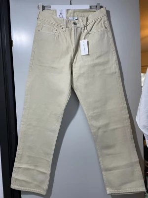 Beige raka jeans från Vailent - Snygga beige jeans från Vailent med klassisk femficksdesign och raka ben. Byxorna har hög midja och är tillverkade i mjuk bomull. Perfekt för dig som gillar stilrena och neutrala färger. Passar till sneakers eller boots.