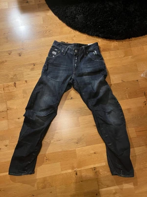 G-star raw jeans - Skit feta g-star raw jeans. Med en mörkblå tvätt och flera små slitningar. Slitningarna är original. Passformen är tapered. Om du undrar något är det bara att skriva. Priset går att diskuteras.