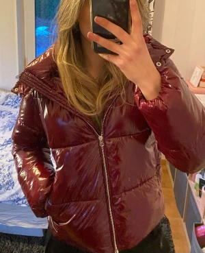 Vinröd pufferjacka från Nelly - Såå fin vinröd pufferjacka från Nelly med avtagbar luva. Köpte förra året och har knappt använt då den är för liten på mig. Skriv gärna om du har några frågor 💕💕