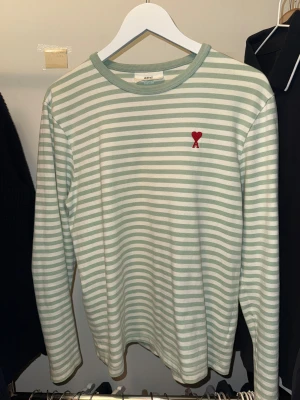 Randig långärmad tröja från Ami - Snygg långärmad tröja från Ami Alexandre Mattiussi i ljusgrönt och vitt randigt mönster.  Tillverkad i mjuk bomull, perfekt för dig som gillar clean och stilren vibe. Storlek M och funkar till allt!! Hör av dig vid frågor😇