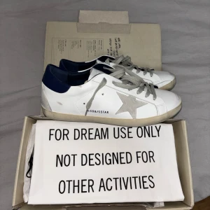 Golden Goose - Säljer sprillans nya vita Golden Goose med grå stjärna.. De är i perfekt skick och ingår med alla tillbehör. Perfekta skor för någon med riktig bra smak 😉 Pris går absolut att diskuteras och går ner vid snabb affär, skickar samma dag. Köpta av en annan person, inget kvitto följde med men allt syftar på  att de är helt äkta. 