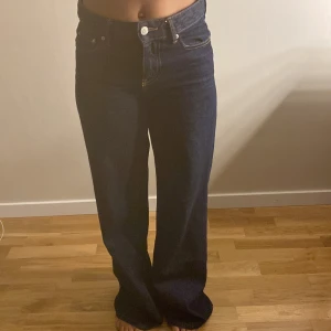 Mörkblå wide jeans från Gina Tricot - Säljer ett par mörkblå 'Perfect Jeans' från Gina Tricot med hög midja och breda ben. Klassisk femficksmodell med kontrastsömmar och knappstängning fram. Snyggt och stilrent snitt som ger en cool vibe till din outfit. Köpte dem i sommars har använt dem typ fem gånger jätte snygga och sköna.