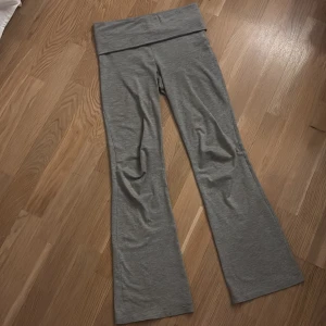 Grå bootcut yoga pants - Snygga grå mjukisbyxor med bootcut-ben och bred linning. Perfekta för chill dagar eller när du vill ha en avslappnad look. Mjukt material som känns skönt mot huden och ger en cool vibe.