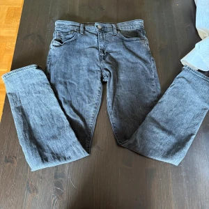 Levi's 502 mörkgrå jeans W30 L32 - Snygga Levi's 502 jeans i mörkgrå tvätt med klassisk femficksdesign och raka ben. Jeansen har normal passform och är tillverkade i slitstarkt denim med detaljer som knappgylf och läderpatch bak i midjan. Perfekt för dig som gillar en clean och tidlös look.