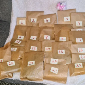 Julkalender Hemmagjord  - 🎄 Hemmagjord lyxig julkalender med 24 överraskningar + en extra fint inslagen bonusgåva som kan öppnas när man vill under december månad! 🎁 Fylld med skönhetsprodukter, smycken och smått & gott – några av påsarna har även små extra saker. Alla presenter är inslagna i silkespapper och ligger i fina enkla bruna påsar som är förslutna så att du enkelt kan använda de till annat🤶🏼   💸 Värde ca 1050 kr, säljes för 350 kr. PM för exakt innehåll ❤️