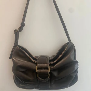 Brun axelväska - Brun axelväska med justerbart axelband. Väldigt snygg och passar till många outfits. Helt ny. Säljer den då jag många bruna väskor och inte fått användning av just denna. 