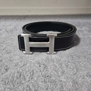 Svart H-bälte - Säljer ett svart H bälte. 110 cm långt. Allt är som det ska. Vid funderingar är det bara o skriva✌️