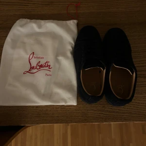  Christian Louboutin sneakers - Säljer ett par marin blåa sneakers från Christian Louboutin med signatur-röd sula och broderad logga på hälen. är tillverkade i mocka med läderfoder. Medföljerdustbag. Perfekt för dig som gillar exklusiv streetstyle. Kan även tvätta till skorna om du vill. skriv om du har funderingar😁