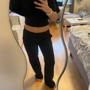 Svarta kostymbyxor  - Snygga svarta kostymbyxor med rak och lite loose passform. Byxorna har klassisk knapp och dragkedja framtill samt fickor på sidorna. Perfekta för en clean och stilren look, passar till crop tops och sneakers. Helt oanvända på grund av att jag köpte för stor storlek.