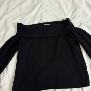 Svart offshoulder stickad tröja H&M - Svart stickad tröja från H&M i storlek M. Snygg offshoulder-modell med bred krage som ger en chill och trendig vibe. Långärmad och mjuk, perfekt för lager-på-lager under höst och vinter. Enkel att matcha med jeans eller kjol.
