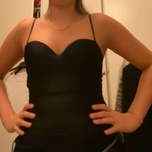 Svart korsett-topp storlek 75B - Helt ny och oanvänd snygg svart korsett-topp med smala axelband och markerad sweetheart-ringning. Toppen är från H&M.