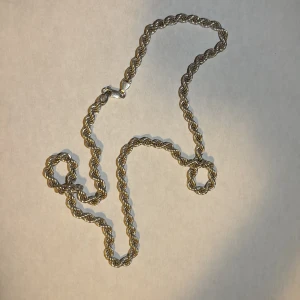 Två kedjesmycken i äkta silver 925 - Säljer ett halsband och ett armband i äkta silver 925. Halsbandet har en snygg tvinnad kedja med karbinlås, medan armbandet har en rundad, tät meshdesign med stämplad 925-detalj. Båda är stilrena och passar perfekt till din smyckessamling. Halsband 60 cm lång armband 21