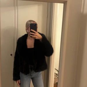 Svart pälsjacka med krage - Säljer en svart pälsjacka med fluffig känsla och bred krage. Strl s