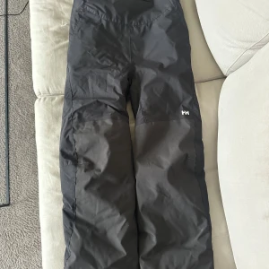 Skidbyxor Helle Hansen syl 152/12 år - Nästan oanvända svarta Helle Hansen skidbyxor för barn.