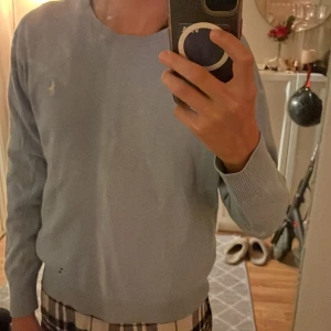 Ljusblå tröja från Polo Ralph Lauren  - Snygg ljusblå tröja från Polo Ralph Lauren i storlek xs . Klassisk rund halsringning, ribbade muddar och nederkant. Broderad logga på bröstet. Perfekt för dig som gillar stilrena och tidlösa plagg.