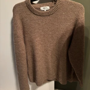 Brun stickad tröja från Gina Tricot - Mysig brun stickad tröja från Gina Tricot i storlek M. Tröjan har rund halsringning, ribbade muddar Perfekt för dig som gillar en enkel och chill stil med lite oversized känsla.