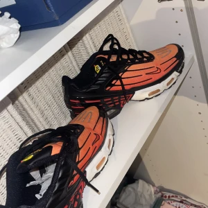 Nike Air Max Plus orange och svarta - Nike Air Max Plus sneakers i en riktigt fet orange och svart färgkombination. Skorna har svarta detaljer, vita och orangea inslag i sulan samt klassisk Tuned Air-dämpning. Swoosh-logga på sidan och mesh-överdel för skön ventilation. Perfekta för dig som vill sticka ut.