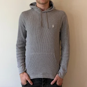Ralph Lauren hoddie  - Säljer en grå hoodie från Polo Ralph Lauren i färgen grå. Riktigt snygg och i fint skick. Storlek M men passar XS-S, modellen på bilden är 177cm. Nypris 1899kr, köp för endast 499kr.