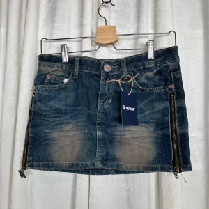 Jeanskjol med dragkedjor  - Mått:   Ytterbensmått 29  cm     Midjemått (mätt rakt över) 36  cm   Grenmått 12  cm                                                               Bra skick. Hör gärna av er vid frågor!                    Följ oss : Instagram a_wearuf                                                         TikTok : awearuf                                                                   (Nr 23) 