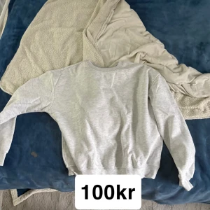 Ljusgrå sweatshirt med rund hals - En enkel och stilren ljusgrå sweatshirt med rund hals och långa ärmar. Tröjan har en klassisk passform och är tillverkad i mjukt bomullsmaterial, perfekt för chill dagar eller när du vill ha en clean look.