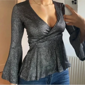 Glittrig omlottopp silver nyår - Nyårs topp!! Glittrig topp med v-ringning och långa ärmar. HELT NY. Perfekt inför nyår! ✨