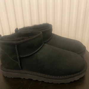 Svarta UGG boots i mocka - Mysiga svarta UGG boots i mocka med rund tå och platt sula. Ny skick