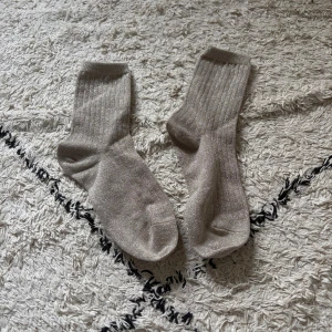 Glittriga ribbade strumpor i silver - Säljer ett par snygga ribbade strumpor i Silver med glittrig finish. Perfekta för att ge outfiten lite extra bling! Strumporna är mellanhöga och har en mjuk och stretchig känsla.