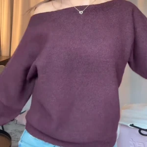 Mörklila offshoulder stickad tröja -  stickad tröja från nelly med offshoulder-design. 