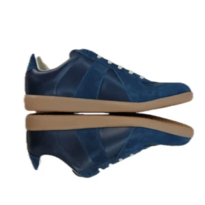 Mörkblå sneakers från Maison Margiela - Säljer ett par mörkblå Maison Margiela sneakers med ovandel i mocka och skinn, vita snören och gummisula. Nypris: 5500kr har använt dem ett få tal gånger!🤩säljer pga att den var för små🥲