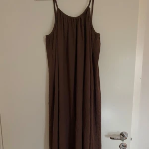 Brun långklänning  - Brun långklänning med öppen rygg (går att knyta åt tightare eller ha mer urringad). NOSIZE 