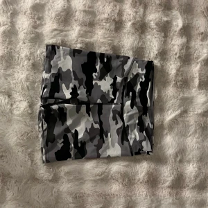 Camouflage bikini i grå toner, strl M - Snygg bikini från 157 i grå, svart och vit camouflage. Bikinin har en sportig look och är tillverkad i ett stretchigt syntetmaterial som sitter skönt på kroppen. Perfekt för dig som vill sticka ut på stranden eller vid poolen.
