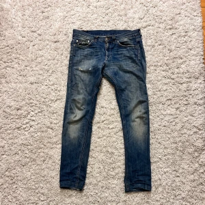 Blåa dondup George jeans med feta slitningar  - Säljer dessa blåa dondup jeans i modellen George, de har feta slitningar på fram och baksida. De har ett hål på den högre bak fickan (som går att laga) de har även lagats i skrevet två gånger. 