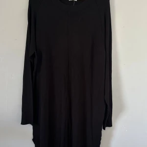 Svart långärmad Stella klänning XL - En svart långklänning från Stella i storlek XL. Klänningen har en enkel och stilren design med rund hals och långa ärmar. Materialet är mjukt och bekvämt, perfekt för dig som gillar minimalistisk stil. Snygg att matcha med boots eller sneakers.  Nypris 499kr