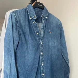 Blå jeansskjorta från Ralph Lauren - Tja släjer nu en riktig schysst jeans skjorta från Ralph Lauren, skick 8/10 inga defekter förekommer. strlk 160