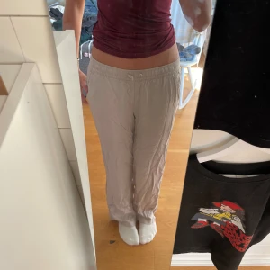 Beiga loose byxor med resårmidja - Säljer ett par beiga linnebyxor med avslappnad passform och resår i midjan. Byxorna har raka ben och sitter väldigt skönt.