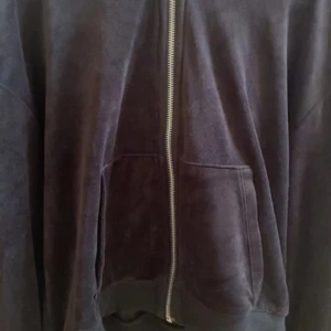 Svart fleece tröja från H&M - Mjuk och skön svart hoodie i velour från H&M. Tröjan har dragkedja framtill, två stora fickor och en rymlig huva. Perfekt för chill dagar eller när du vill ha något riktigt bekvämt på dig.