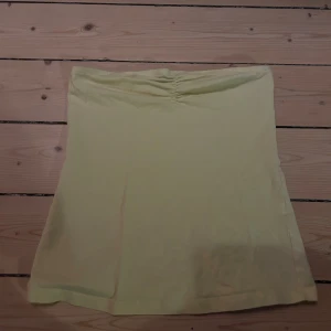 Gul kortkjol från Esmara - Söt gul tubetop från Esmara i mjukt bomullstyg. tubetopen har en enkel, rak design med lätt utsvängd form och diskret rynk vid brösten. Perfekt för dig som gillar ljusa färger och en clean look.