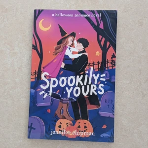 Spookily Yours - BOKEN ÄR I NY SKICK. En Halloween-inspirerad romantisk berättelse om en häxa och en demon, perfekt för dig som gillar magi, humor och kärlek. Färgstark och charmig, med en katt som är mer än den verkar. Passar unga vuxna som vill ha en mysig och spännande läsupplevelse.
