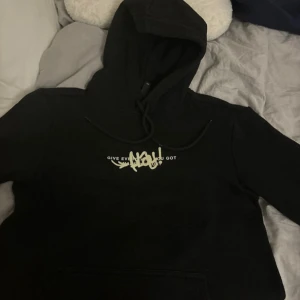 Svart hoodie med PLAY! print - Svart hoodie med stor PLAY! graffiti-print på ryggen och basketmotiv. Framsidan har texten 'Give everything you got' och snörning vid huvan. Perfekt för dig som gillar streetwear och sportig stil.